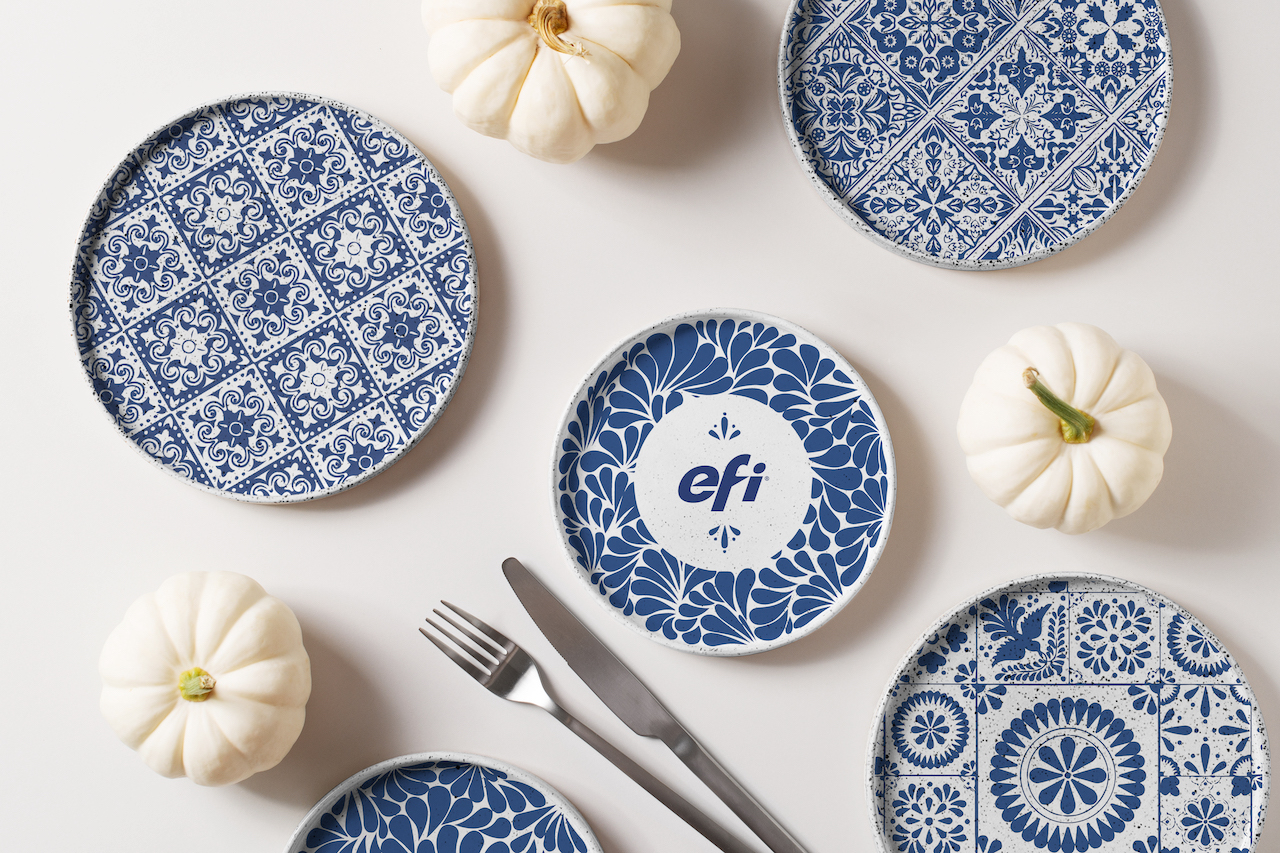 Cermaic plates with blue patterns on a table with silverware and white pumpkin decorations.